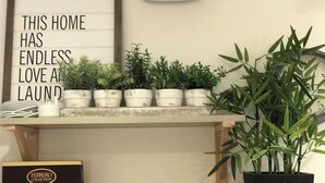 A shelf with potted plants, a sign, and a box. - Lovely 1 bedroom, with parking & patio, 5 min walk from Lexicon  & Train Station (Bracknell)