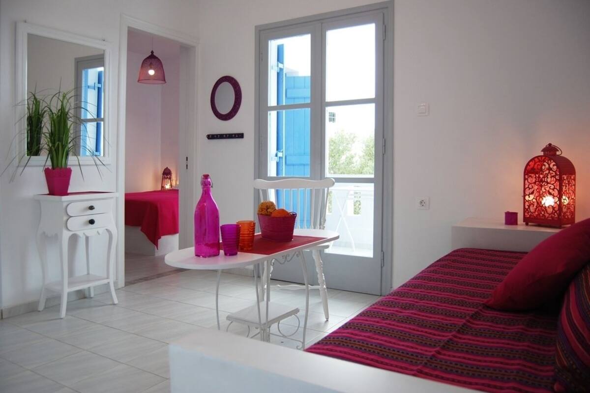 Una habitación luminosa con cama, escritorio y ventana.