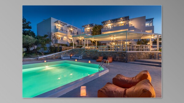 Una piscina al aire libre de temporada, sombrillas, tumbonas