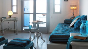 Ein Schlafzimmer mit Bett, Nachttisch, Lampe und Blick ins Freie.