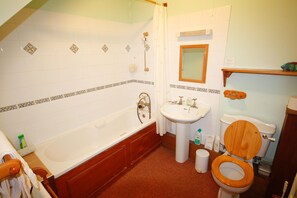 Ein Badezimmer mit Badewanne, Waschbecken, Toilette und Duschvorhang.