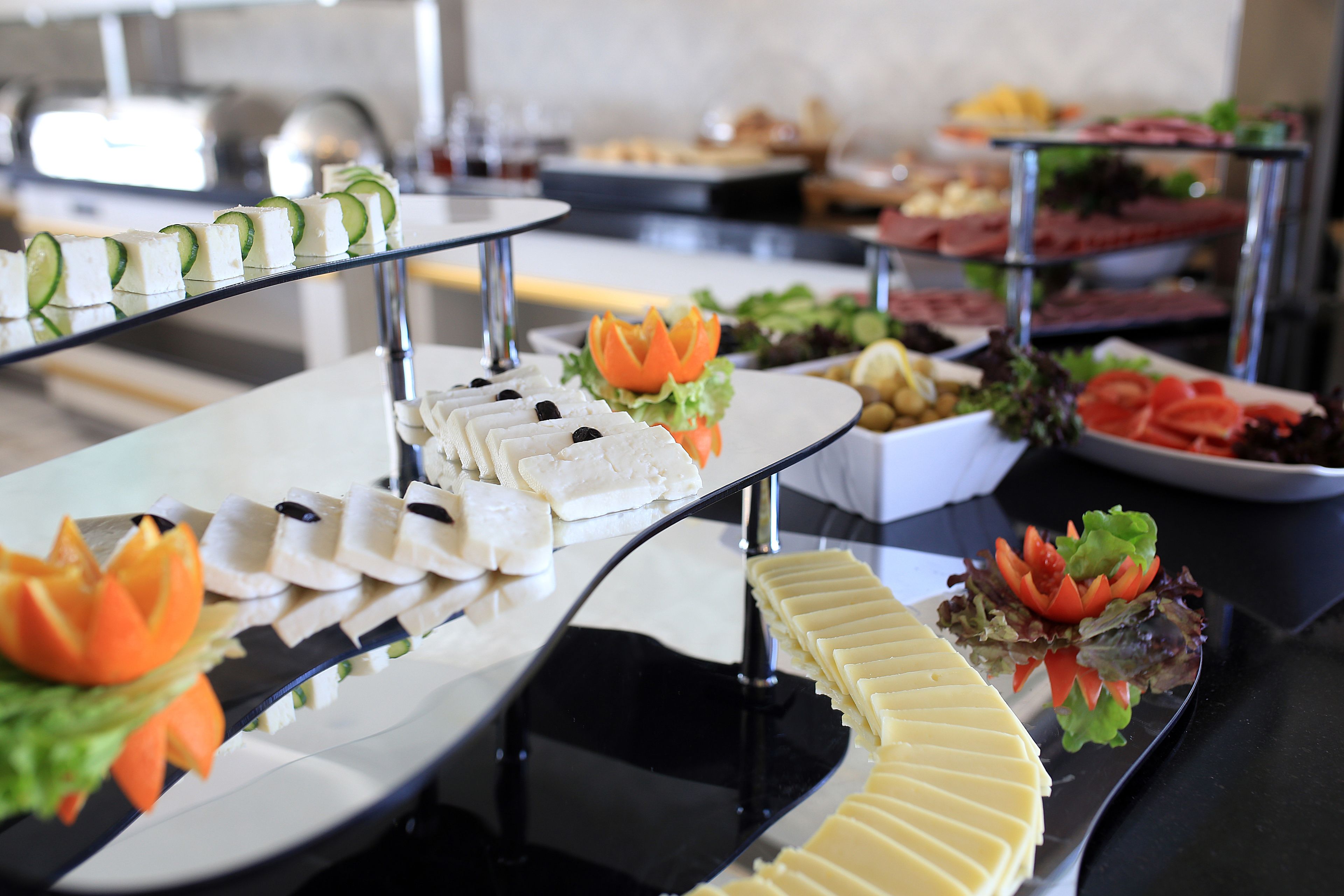 Een buffet met diverse gerechten, waaronder kaas, groenten en vlees.
