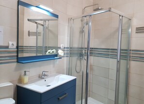 Chuveiro, secador de cabelo, toalhas de banho, papel higiênico
