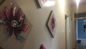 Un pasillo decorado con tres cuadros de motivos florales.