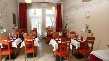 Un espace repas comprenant plusieurs tables et chaises, disposées de manière à créer un aménagement spacieux.