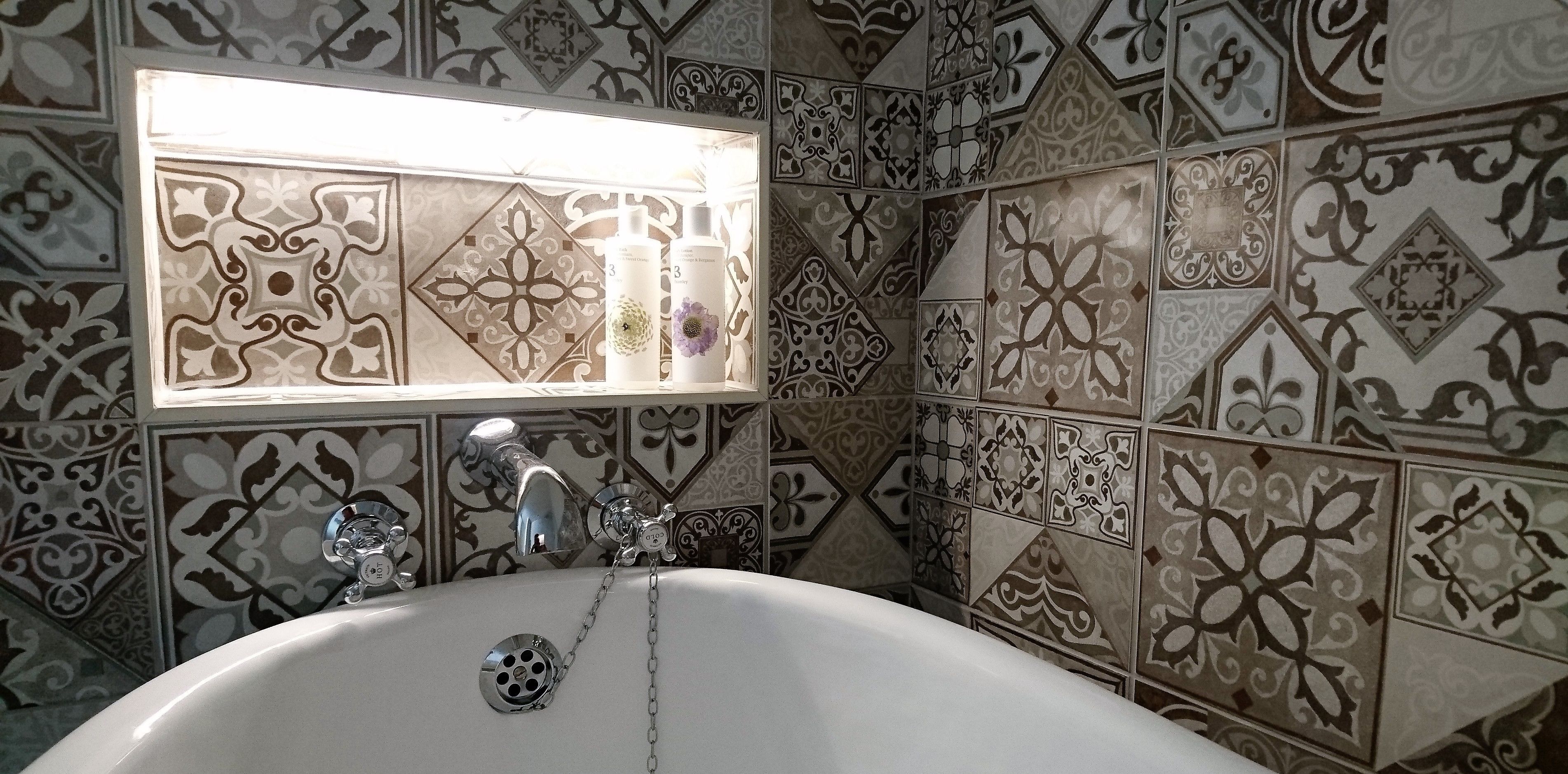A bathroom with a white bathtub, a chrome faucet, and a window above the sink.