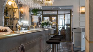 A bar area with a counter, stools, and a decorative plant. - Söderköpings Brunn (Soderkoping)