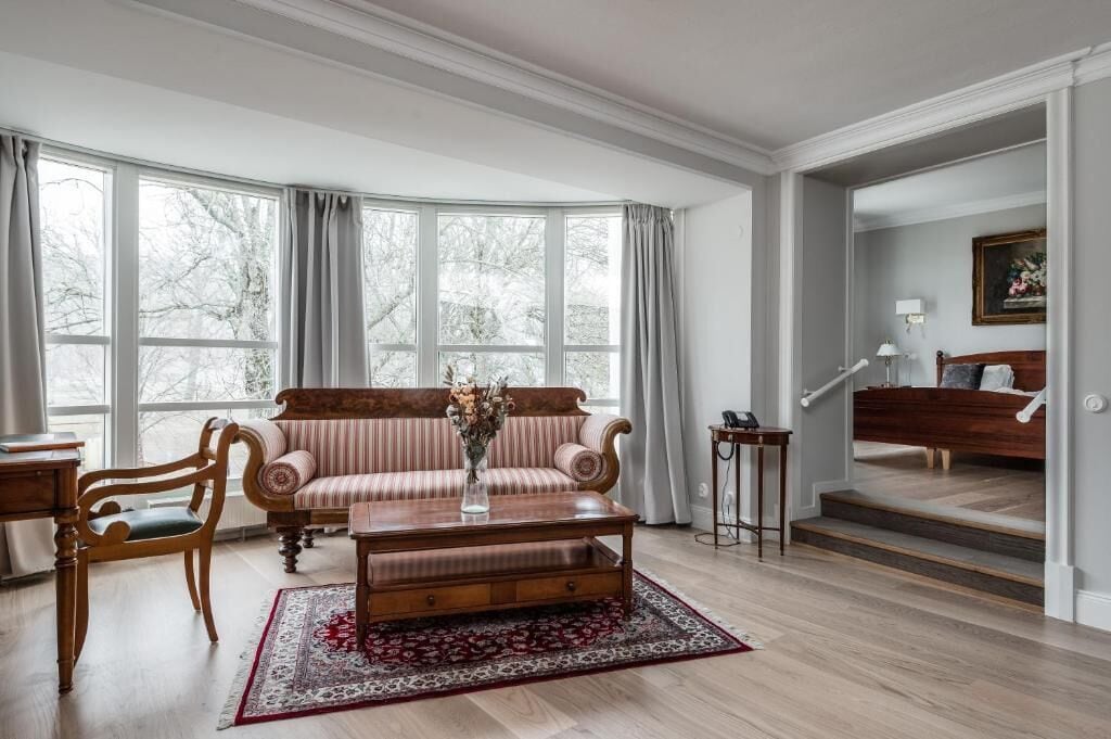 A living room with a sofa, a coffee table, and a chair. There is a staircase leading to an upper level.