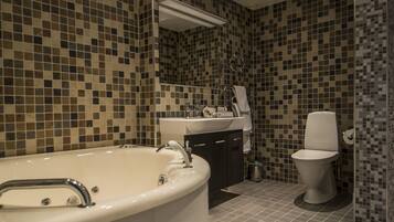 Une salle de bain moderne avec une baignoire sur pieds, un lavabo, des toilettes et un miroir.