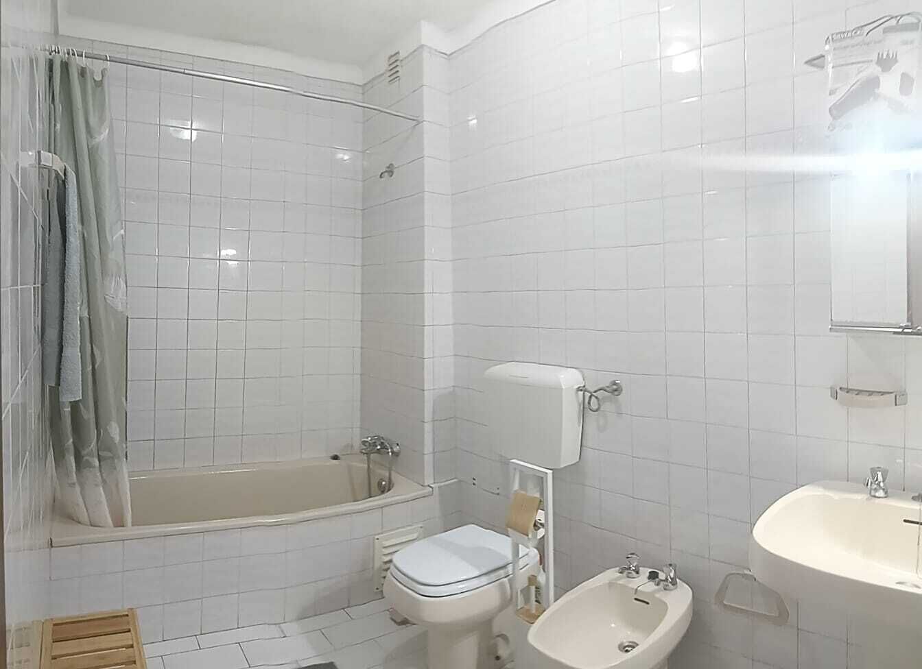 A bathroom with a bathtub, toilet, bidet, and sink.