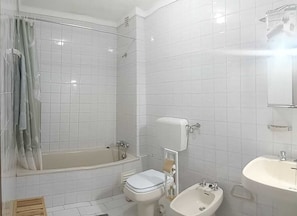Tina con regadera, secadora de cabello, bidet, toallas