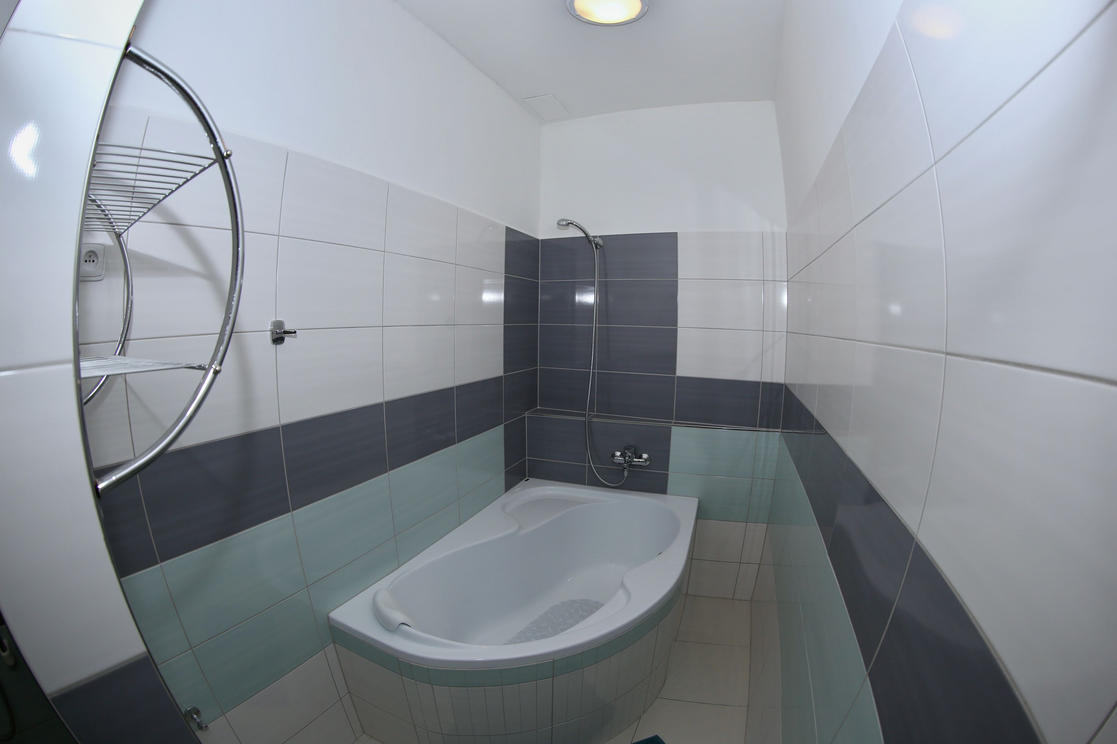 A bathroom with a bathtub, a shower, and a towel rack.