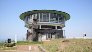 Une tour d’observation circulaire, dotée d’un escalier en colimaçon, d’une base en pierre et de grandes fenêtres.