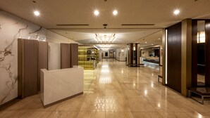 A spacious hotel lobby with a marble reception desk, a chandelier, and a reception area with a counter. - ANA Crowne Plaza Akita by IHG (Akita)