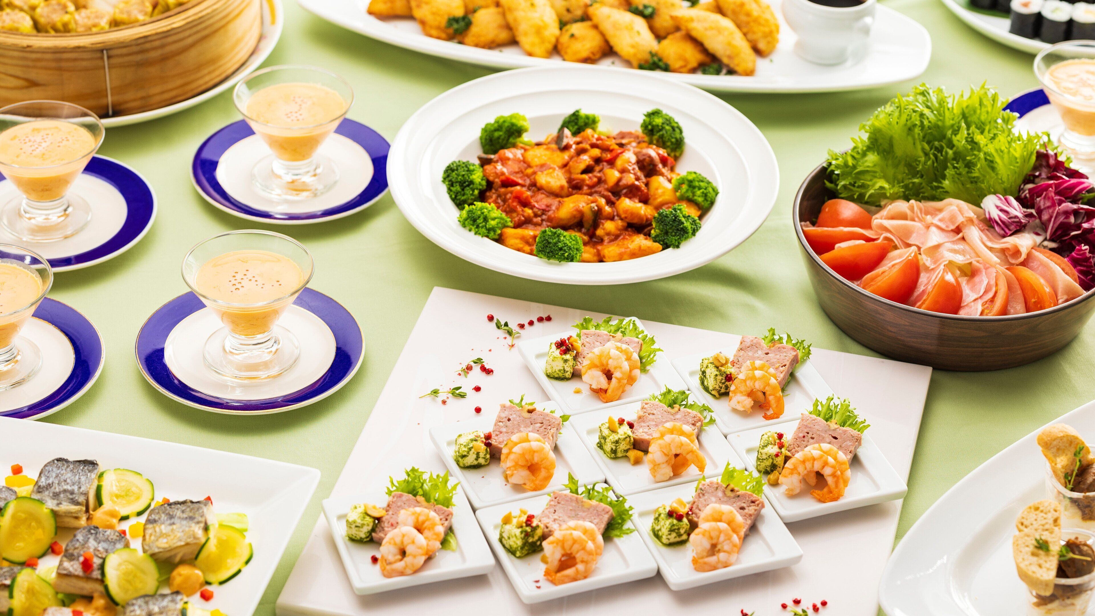 A variety of dishes including seafood, vegetables, and a dessert.