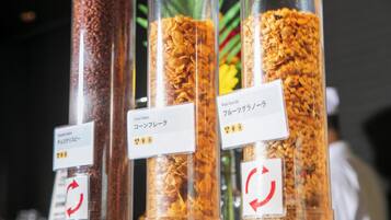 Four containers of different cereal flakes with labels in a foreign language.