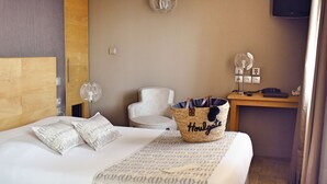 Een hotelkamer met een bed, een stoel, een bureau en een televisie.