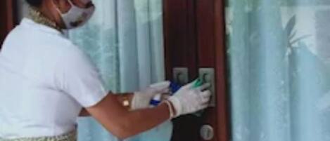 Una persona limpiando una puerta de madera con un pulverizador.