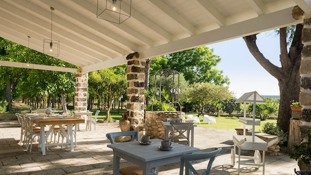 An outdoor patio area with stone pillars, tables, and chairs. - Dimora del Duca Masseria B&B (Monteroni di Lecce)