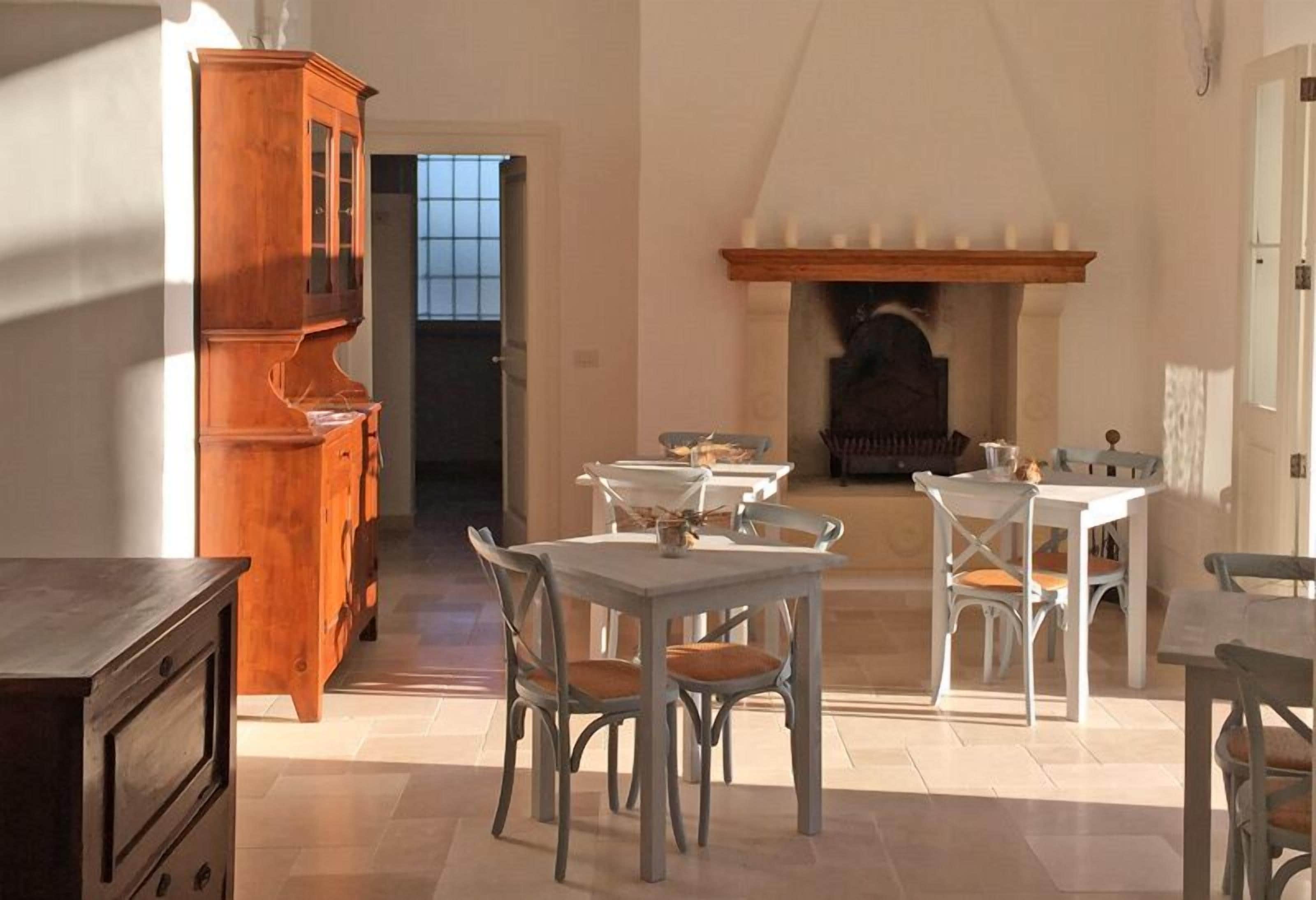 Comedor con chimenea, mueble de madera y juego de comedor blanco.