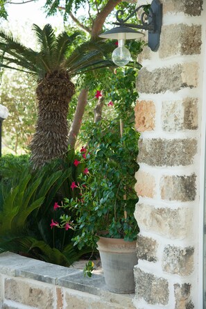 A stone wall with a potted plant and a hanging light fixture. - Dimora del Duca Masseria B&B (Monteroni di Lecce)