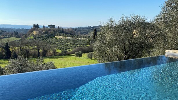 An infinity pool with clear water, surrounded by lush greenery and a view of rolling hills. - Frantoio - Il Casale di Villore, Poggibonsi, Siena, Tuscany (Poggibonsi)