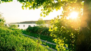 Un sentier qui longe la rivière, avec un pont en arrière-plan.
