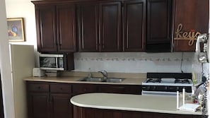 Fridge, microwave, coffee/tea maker, cookware/dishes/utensils