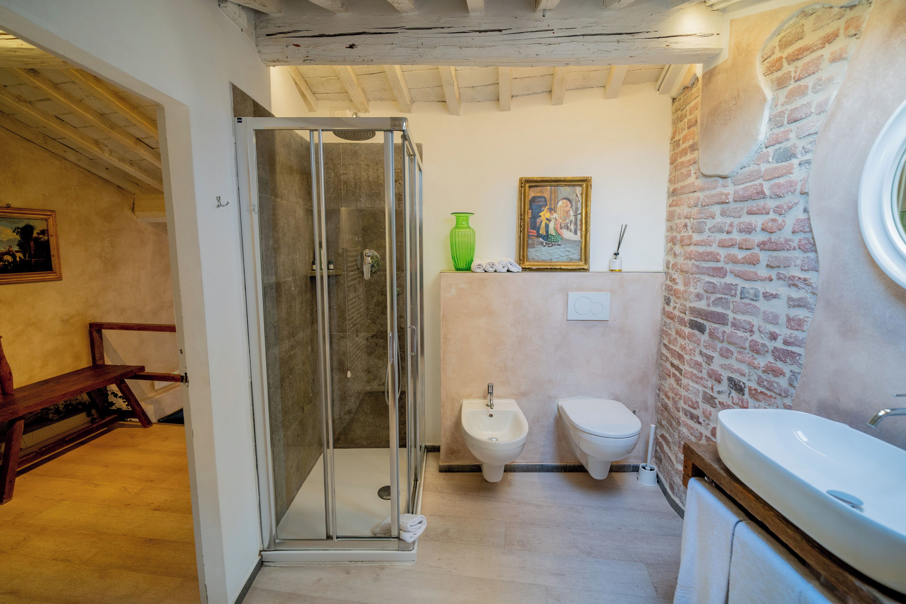 Un baño con ducha de vidrio, un bidé, un inodoro y un lavamanos.