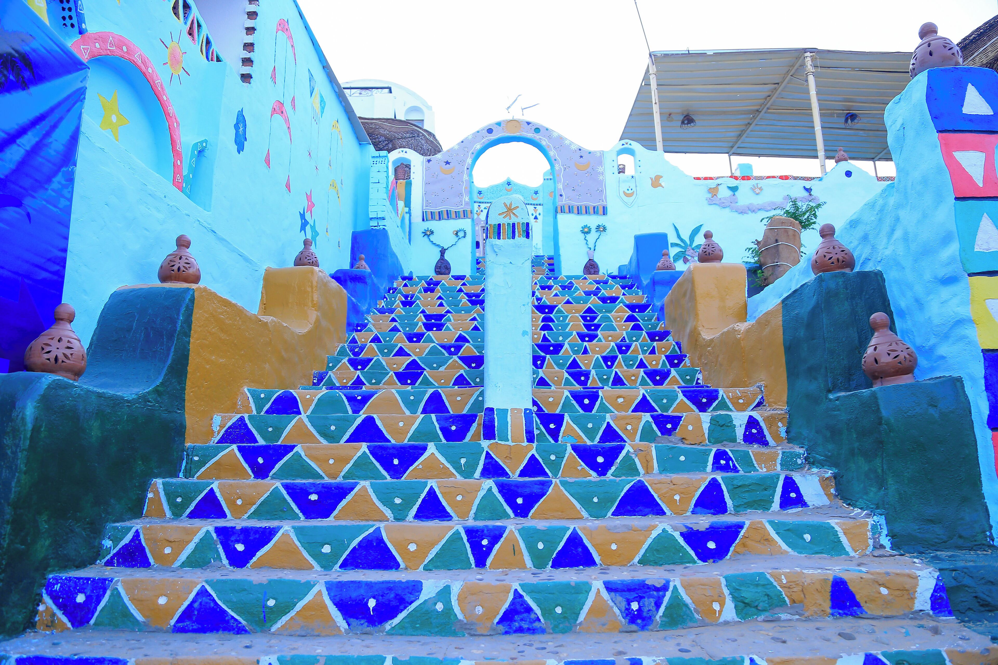 A staircase with colorful geometric patterns leading to a central archway.