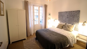 A bedroom with a bed, a wardrobe, a door, and a patterned headboard. - Comfortable house with magnificent garden (Ponta Delgada)