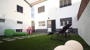 A courtyard with artificial grass, a play tent, and a lounge chair. - Comfortable house with magnificent garden (Ponta Delgada)