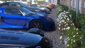 A row of parked sports cars along a gravel path beside a building with a wooden facade. - l'Aérodrome de la Baie de Somme (Buigny-Saint-Maclou)