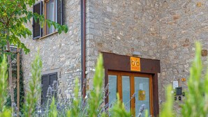 A stone building with a wooden door and shutters, a sign reading "b.v. eroico", and a number "19" on the wall. - L' Eroico (Gaiole in Chianti)