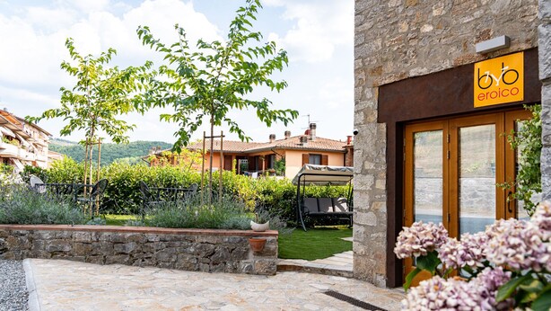 A stone building with a yellow sign reading "b&b erioico". - L' Eroico (Gaiole in Chianti)