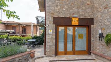 Ein Steinhaus mit einer Holztür und einem Schild, auf dem "bb enoteca" steht.