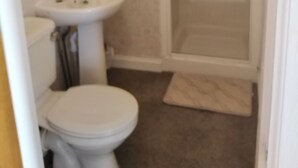 A bathroom with a toilet, sink, and shower. - Camillia Guest House (Aberdeen)