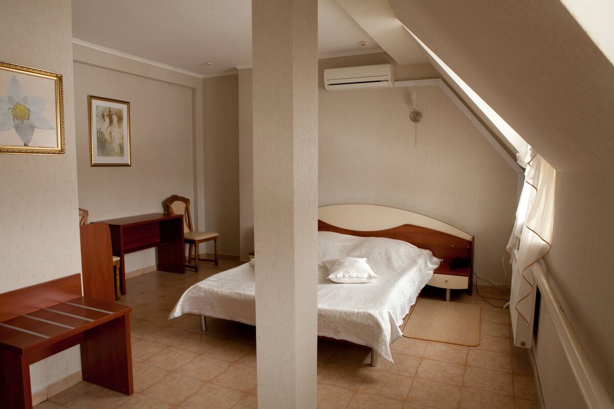 Un dormitorio con una cama, un escritorio y una silla.