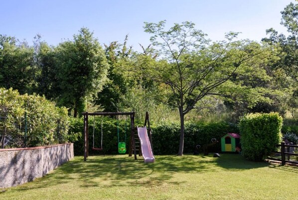 A playground with a slide and swings, surrounded by trees and a small shed. - Apt. LaTraviata - Residence Casa lama - two-room apartment 2/4 P for couples or families (Castelfranco di Sopra)