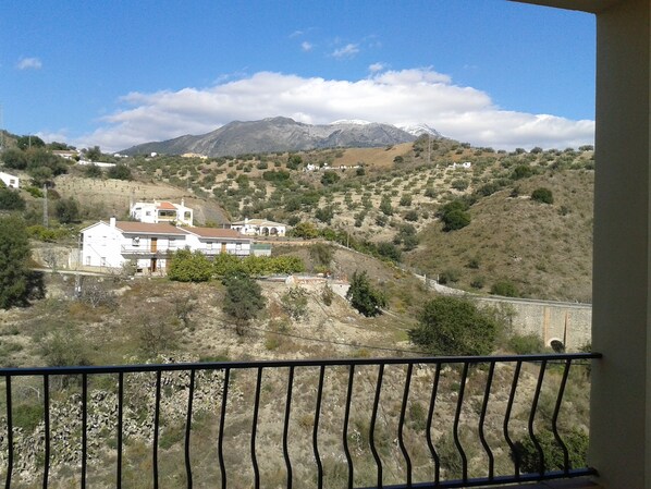 A mountainous landscape with a white building and a balcony. - Apartment 3 Vista La Maroma (Viñuela)