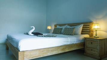 A single bed with a wooden frame, two bedside lamps, and a swan decoration on the bed.