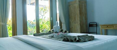 Habitación de hotel con cama, armario de madera y vistas a zonas verdes.