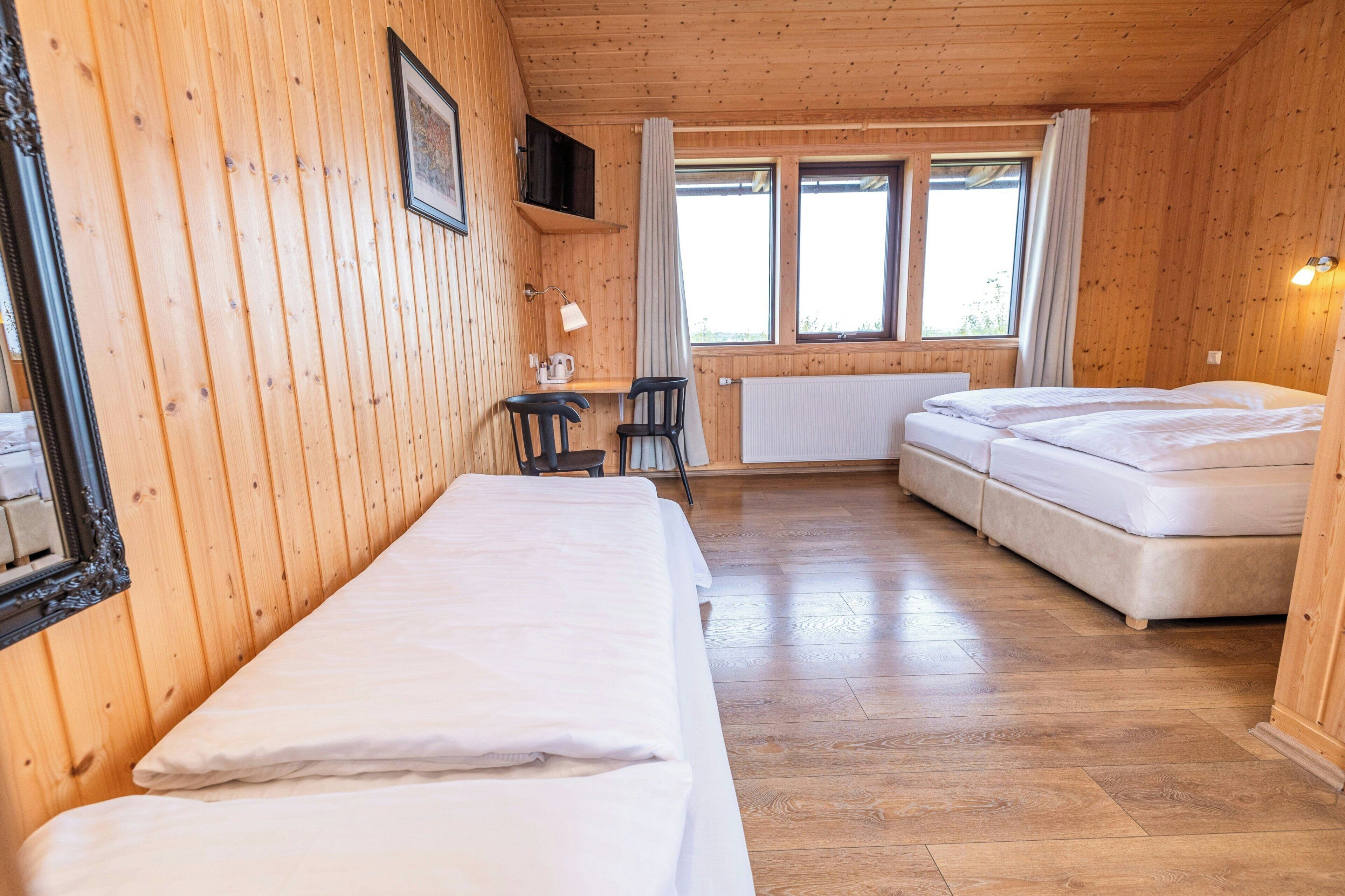 Une pièce de style cabane en bois, comprenant un lit, un bureau et un canapé.
