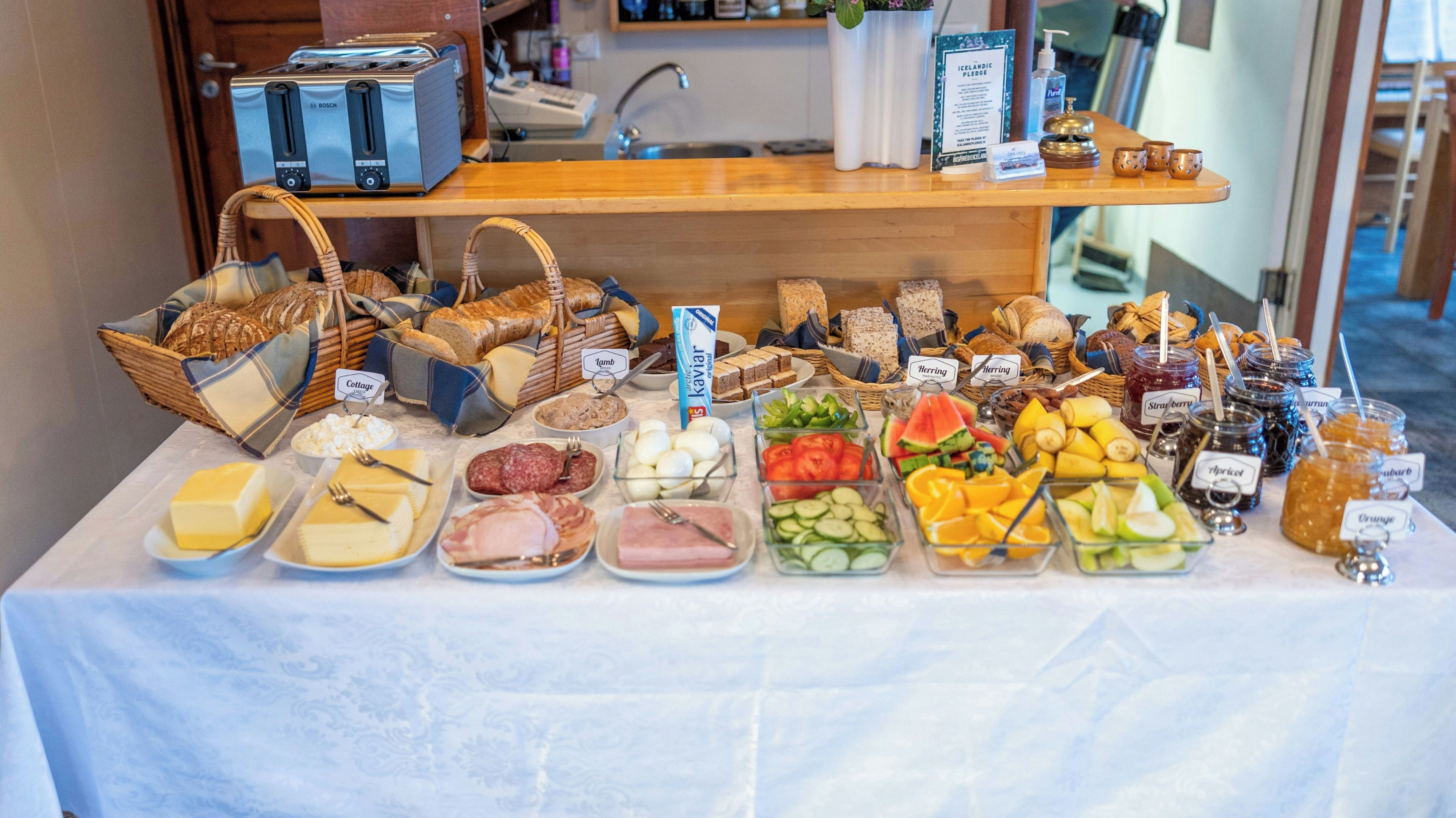 A buffet table with various food items and labels.