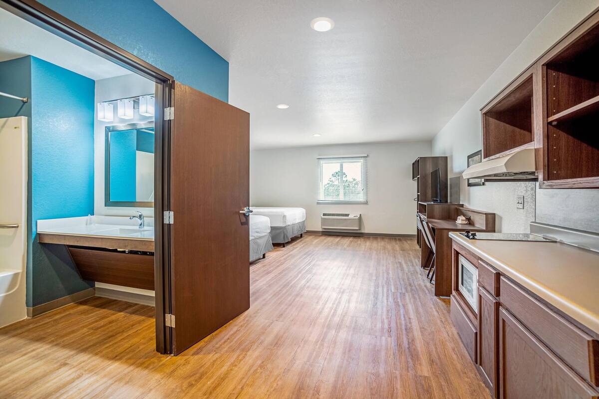 Une salle de bain moderne avec un meuble-lavabo en bois, un grand miroir et un espace douche.