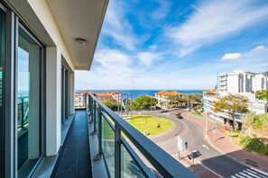 A balcony with a view of a roundabout and buildings, overlooking a coastal area. - Monumental Apartment - By Wehost (Funchal)