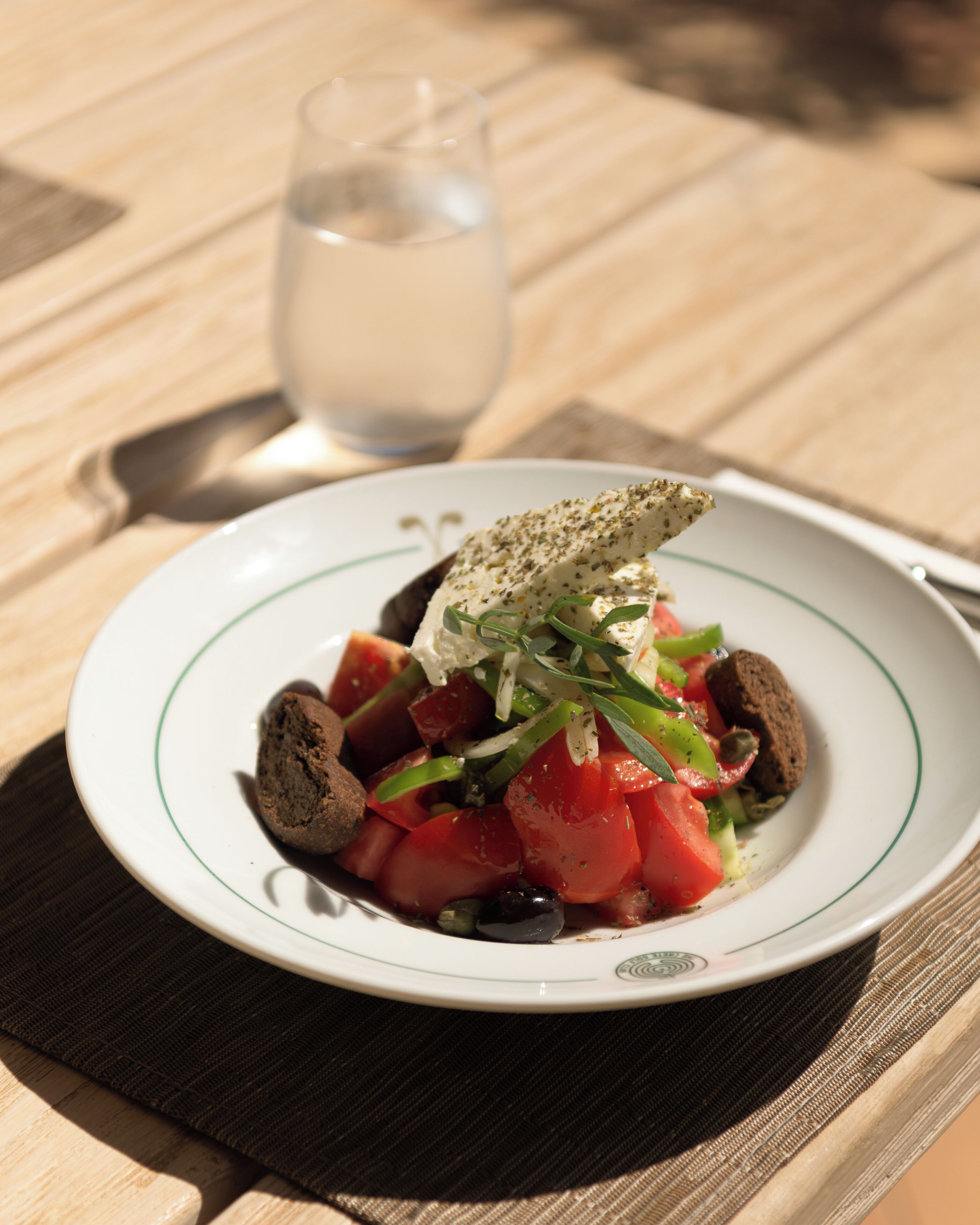 A plate of food with a glass of water on a table.