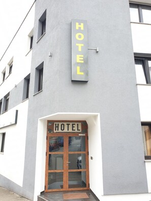 A hotel entrance with a sign above the door that reads "HOTEL". - Kirchberg Hotel (Saarbrücken)