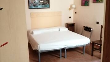 Une chambre à coucher comprenant un lit, une chaise, un climatiseur fixé au mur et un tableau.