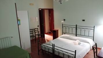 Quarto com cama, cadeira, mesa e radiador.